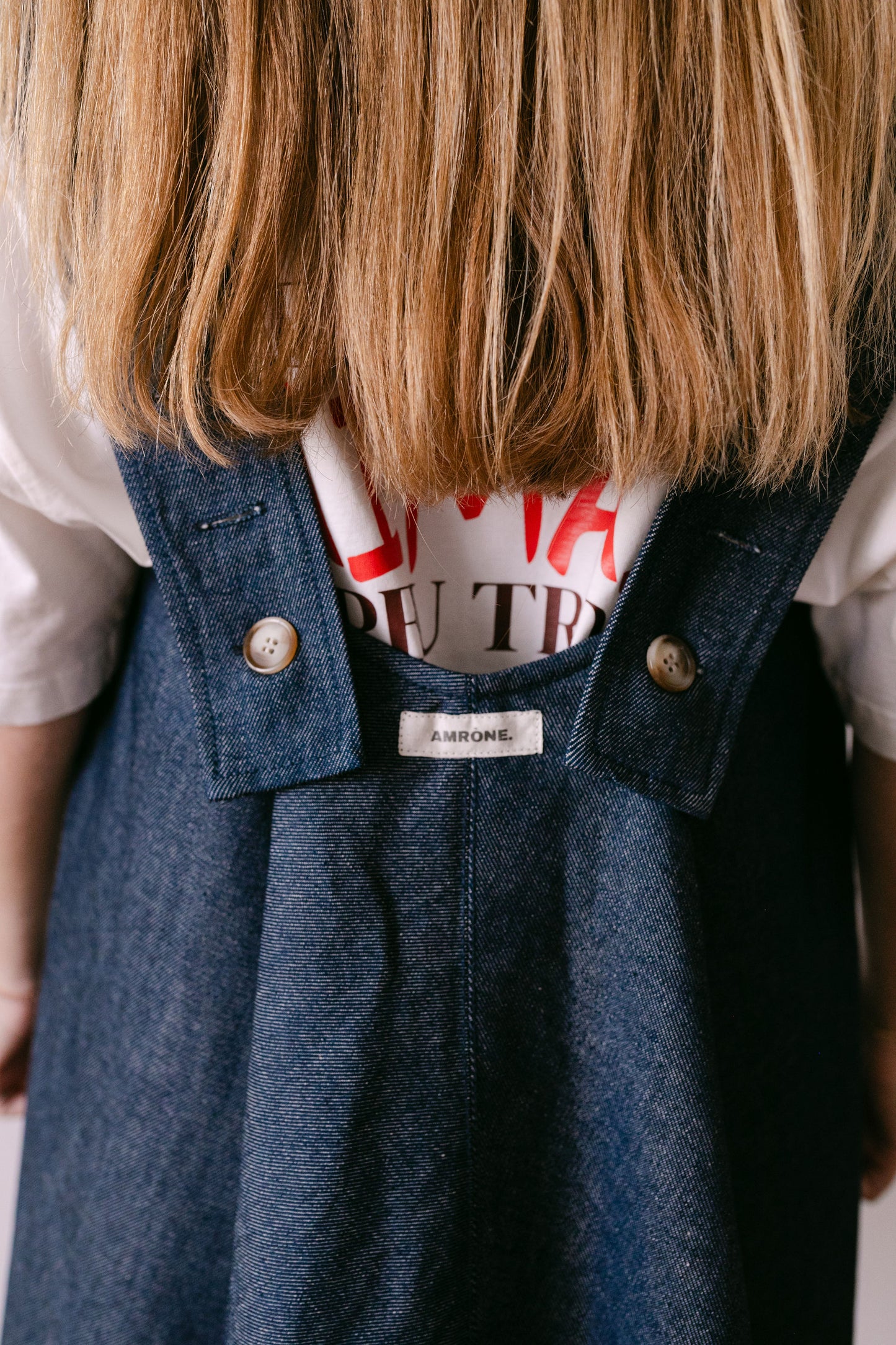 Robe denim dos nu avec des bretelles ajustables. Portée sur le tee shirt blanc Amrone. 
made in France. marque Amrone 
